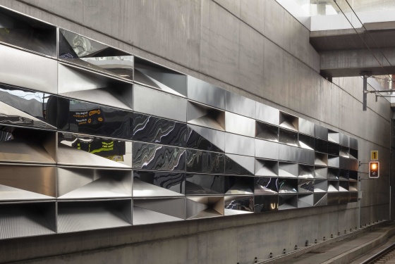 Kunstverk bestående av glinsende flater lagt som fliser, som reflekterer omgivelsene på Bergen Lufthavn Flesland